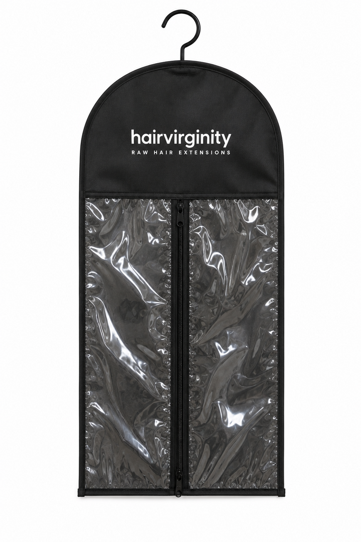 A black hair extension garment bag with a hanger, featuring two clear plastic zippered compartments and the brand name 'hairvirginity' printed in white at the top.